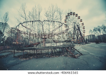 Abandoned carousel and abandoned ferris  at an amusement park in the center of the city of Pripyat, the Chernobyl disaster, the exclusion zone, a ghost town