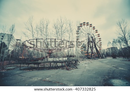 Abandoned carousel and abandoned ferris  at an amusement park in the center of the city of Pripyat, the Chernobyl disaster, the exclusion zone, a ghost town