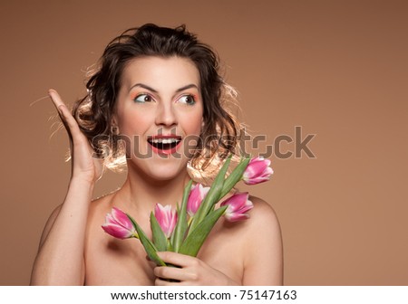 Portrait of a beautiful girl with a bouquet of tulips and wow emotion, closeup.