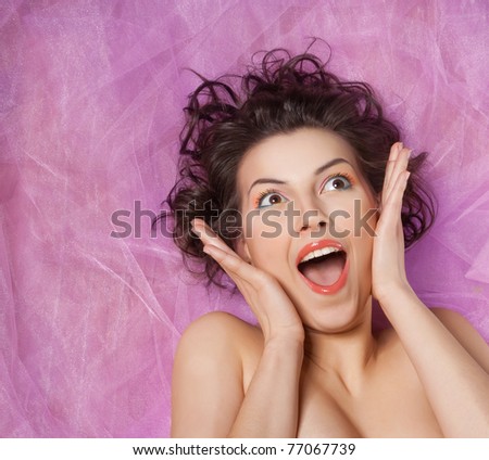 Close-up studio portrait of a beautiful girl with the emotion of delight
