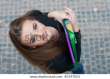 Portrait of a young student with colored folders, European, White, Caucasian