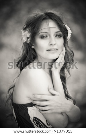 Black-and-white hortrait of beautiful young woman with daisies in her hairoutdoors, park, European, White, Caucasian