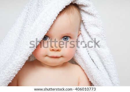 little baby smiling under a white towel