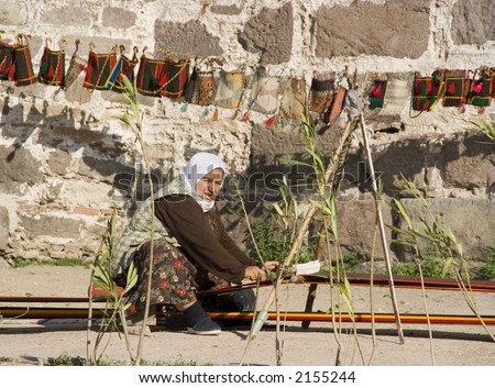 Woman weaving a carpet in Izmir citadel (Turkey)