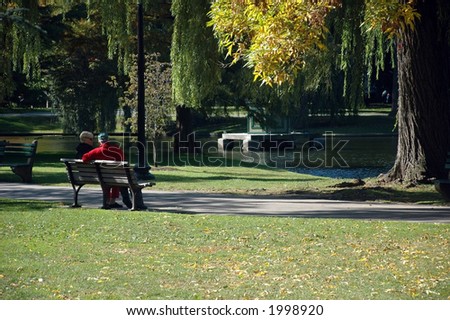 Elderly couple enjoying trees showing their fall colors in the Public Garden, Boston Common, Boston, Massachusetts.