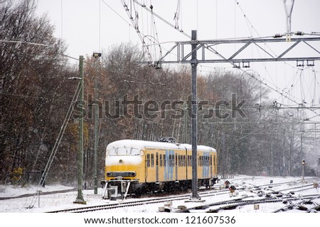 A train is waiting on a snow covered train station in the winter