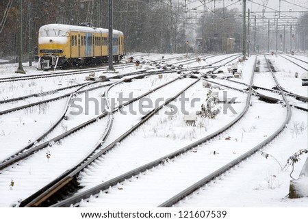 A train is waiting on a snow covered train station in the winter