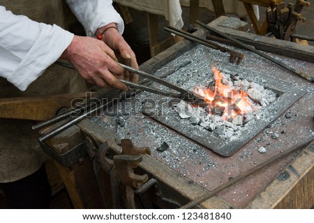 Blacksmith at work heating up the iron in the fire