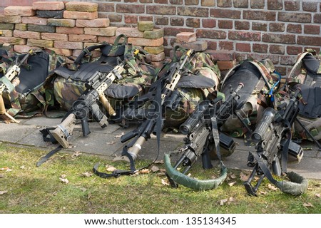 Automatic weapons lying against a wall during a training of the army
