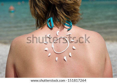A woman with suntan on her back in the shape of the sun