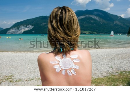 A woman with suntan on her back in the shape of the sun