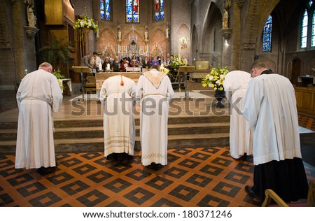HENGELO, NETHERLANDS - APRIL 09: A priest, a cardinal with their helpers are bowing towards the altar at the end of a mass in the catholic \'Onze Lieve Vrouwekerk\' church of Hengelo, April 09, 2012