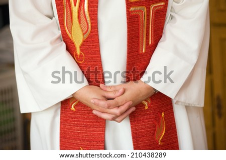 A female priest is folding her hands during praying