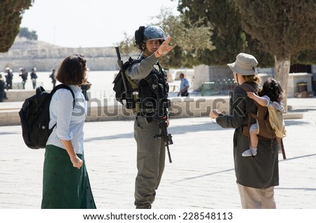 JERUSALEM, ISRAEL - OCT 08: Israeli police officer tells tourists to go backward on the temple-square in Jerusalem during religious fightings with muslims, October 08, 2014 in Israel