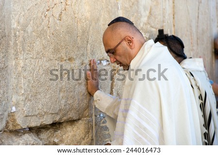 JERUSALEM, ISRAEL - OCT 06, 2014: Two jewish man are praying against the western wall in the old city of Jerusalem