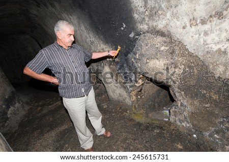 JERUSALEM, ISRAEL - OCT 06, 2014: A guide is showing the tomb where the prophet Zechariah was buried, in the \'Tombs of the Prophets\' on the mount of olives in Jerusalem.
