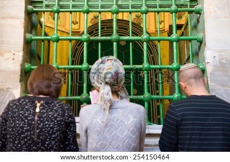 HEBRON, ISRAEL, 10 OCT, 2014: Three jewish people are praying in front of the tomb of patriarch Abraham. The tombs of the patriarchs are situated in the Cave of Machpelah in Hebron