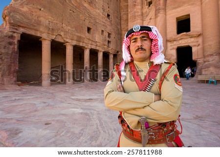 PETRA,  JORDAN - OCT 12, 2014: A guard in ancient costume in front of one of the royal tombs in Petra in Jordan