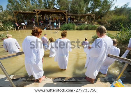 YERICHO, ISRAEL - OCT 15, 2014: Religious christians with white clothes going into the water of the Jordan river at baptismal site Qasr el Yahud near Yericho