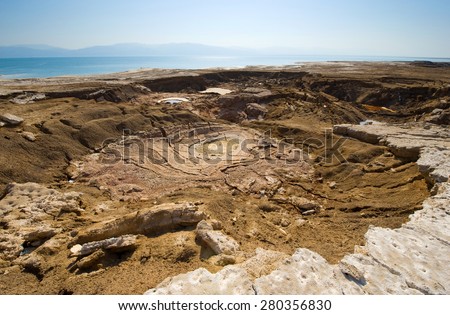 Sinkhole or open pit on the shore\'s of the dead sea at the end of the summer when the water level is at it\'s lowest