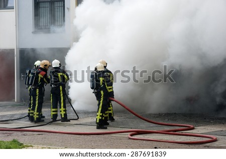 ENSCHEDE, THE NETHERLANDS - 07 MAY, 2015: Firefighters are busy to extinguish a fire in a house