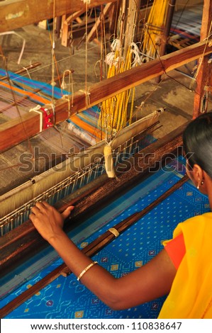 Unidentifiable textile worker weaving Ikkat saree at India