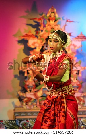 ORISSA, INDIA - NOV 17: An 8 year old boy, named as Ambika, dances in Gotipua festival against a colorful backdrop on November 17, 2011 at Orissa, India. Gotipua is a form of folk Odissi dance.