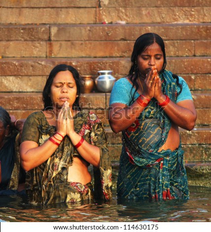 VARANASI, INDIA - APRIL 1: Hindu women do Surya Namaskar (worship Sun God) in holy water of Ganges on April 1, 2011 at Varanasi, Uttar Pradesh, Central India.