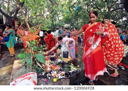 KOLKATA, INDIA - October 15: Married Hindu ladies worship a holy tree and Shiva lingam on October 15, 2012 at Kolkata, India. This ritual takes place annually and is known as Tarpan.