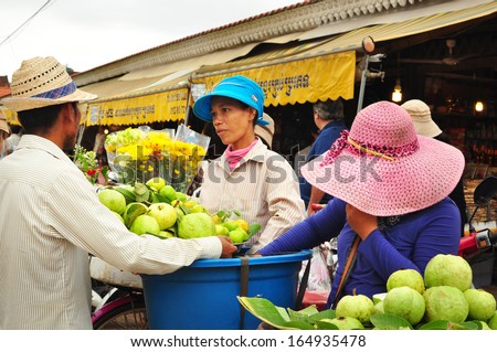 SIEM REAP, CAMBODIA  - NOVEMBER 13: Lady fruit sellers do business in local market on November 13, 2013 in Cambodia. Cambodian women are leading a good role to boost their economy in recent years.