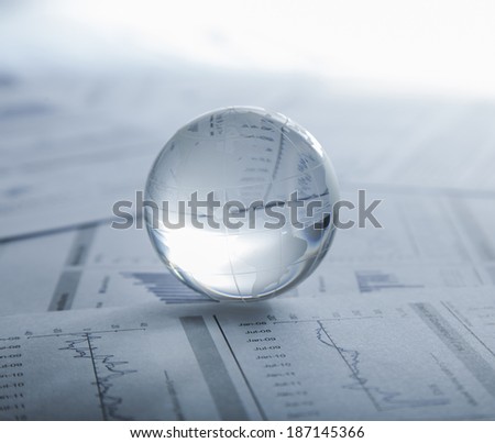 Glass globe on the chart papers.