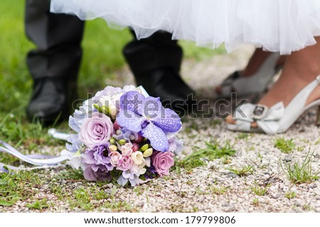 wedding bouquet and feet of the bride and groom