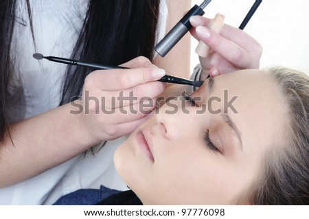 Make-up artist woman fashion model apply eyeshadow with brush