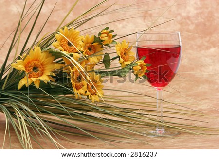 Red wine and yellow daisy flowers
