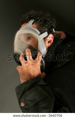 Man covering his face with gas mask