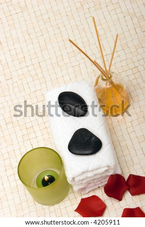 Spa towels, massage stones, fragrance sticks, candle and rose petals