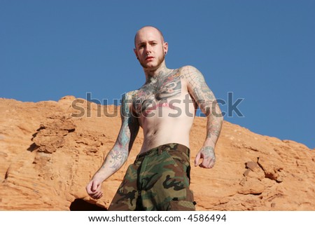Athletic tattooed man on blue sky