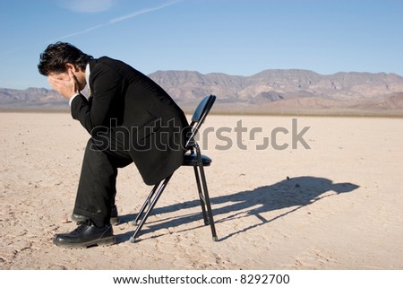 Businessman sitting alone in the empty desert