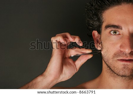 Man pulling his beard with tweezers