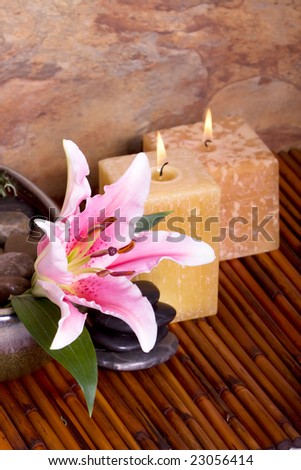 Massage stones, candle and pink lily