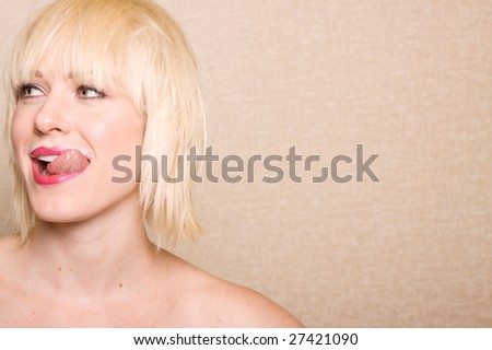 Beautiful woman sticking her tongue out after drinking milk