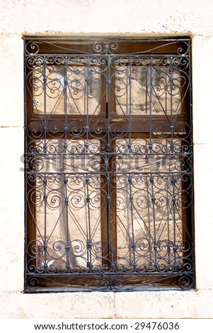 An antique house window with rusty metal frame