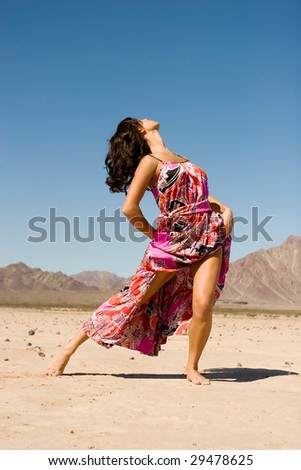 Young female model wearing fashionable dress in desert