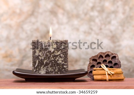 Candle and cinnamon sticks on antique background
