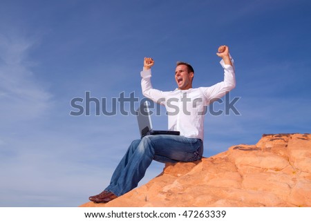 Man celebrating his success in front of his laptop