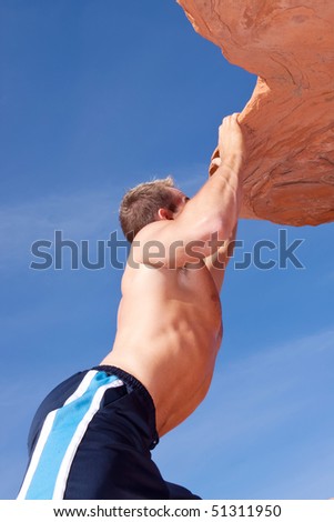 Athletic rock climber on red rocks