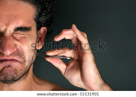 Young man pulling his beard with tweezers