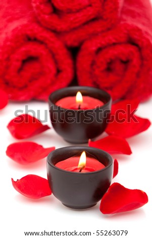 Spa decor with candle, towel and red rose petals