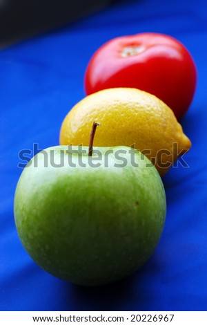 Concept of fruits representing traffic light on blue background (perspective with thin depth of field)