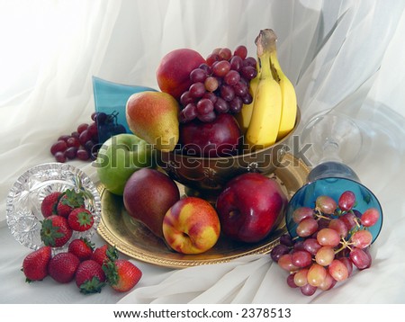 Brass bowl overflowing with grapes, nectarines, apples, pears, bananas, strawberries and grapes.